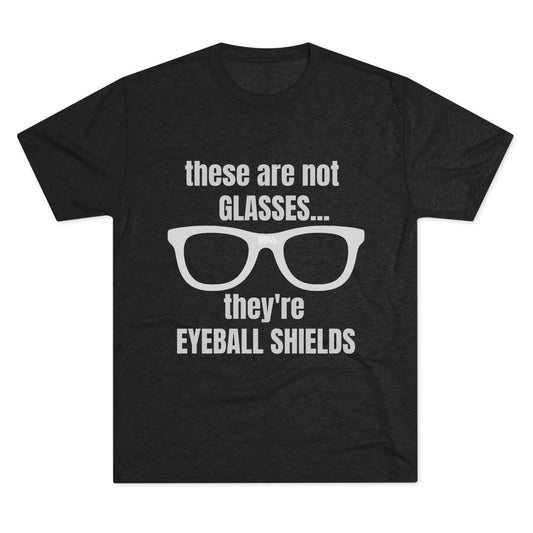 Light heather tri-blend tee flat-laid, printed with glasses graphic and text ‘these are not GLASSES... they’re EYEBALL SHIELDS.