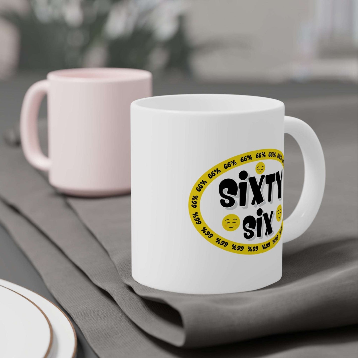 Graphic mug showing ‘Sixty Six’ in bold black type surrounded by a yellow border of small ‘66%’ repeats, with 2 cheerful emoji faces and 1 sad face.