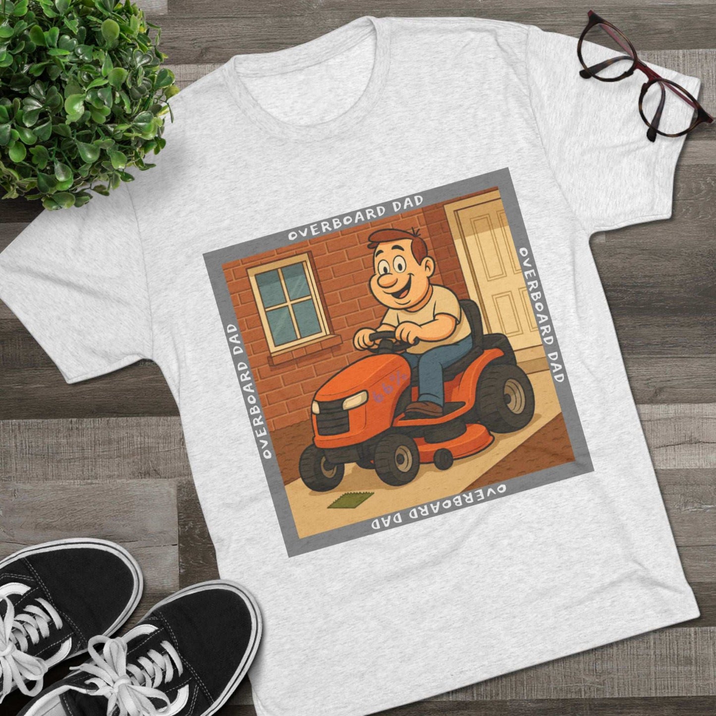 Overboard Dad Mower 66% Tri-Blend Tee — graphic tee, flat-lay with cartoon dad on ride-on mower, gray ‘OVERBOARD DAD’ square border, 66% decal, casual vintage style.