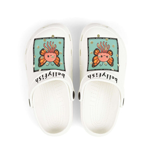White slip-on clogs decorated with colorful Jibbitz: each shoe has a teal square graphic showing a cute jellyfish with butterfly wings and scattered gold dot accents, plus ‘Bellyfish’ branding on the straps