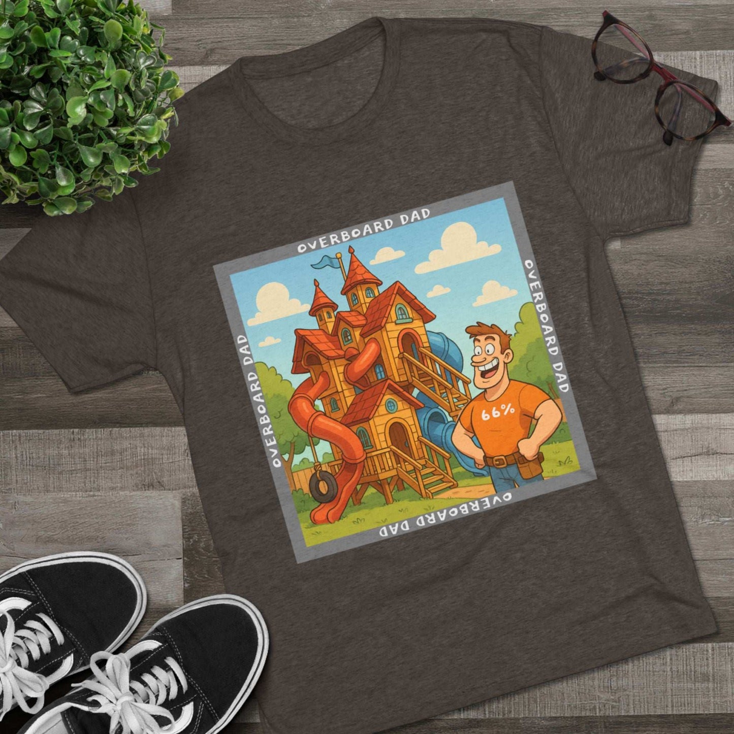 Funny cartoon dad standing proudly beside an enormous playhouse castle with slides, “Overboard Dad 66%” design on bright blue tri-blend t-shirt