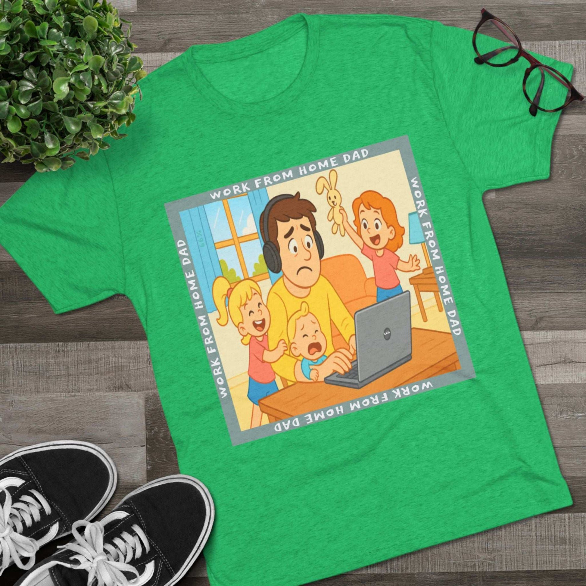 Work From Home Dad 66% Tri-Blend Tee — graphic tee flat-lay, cartoon dad with headphones typing on 66% laptop, three kids demanding attention, green WORK FROM HOME DAD square border, casual unisex style.