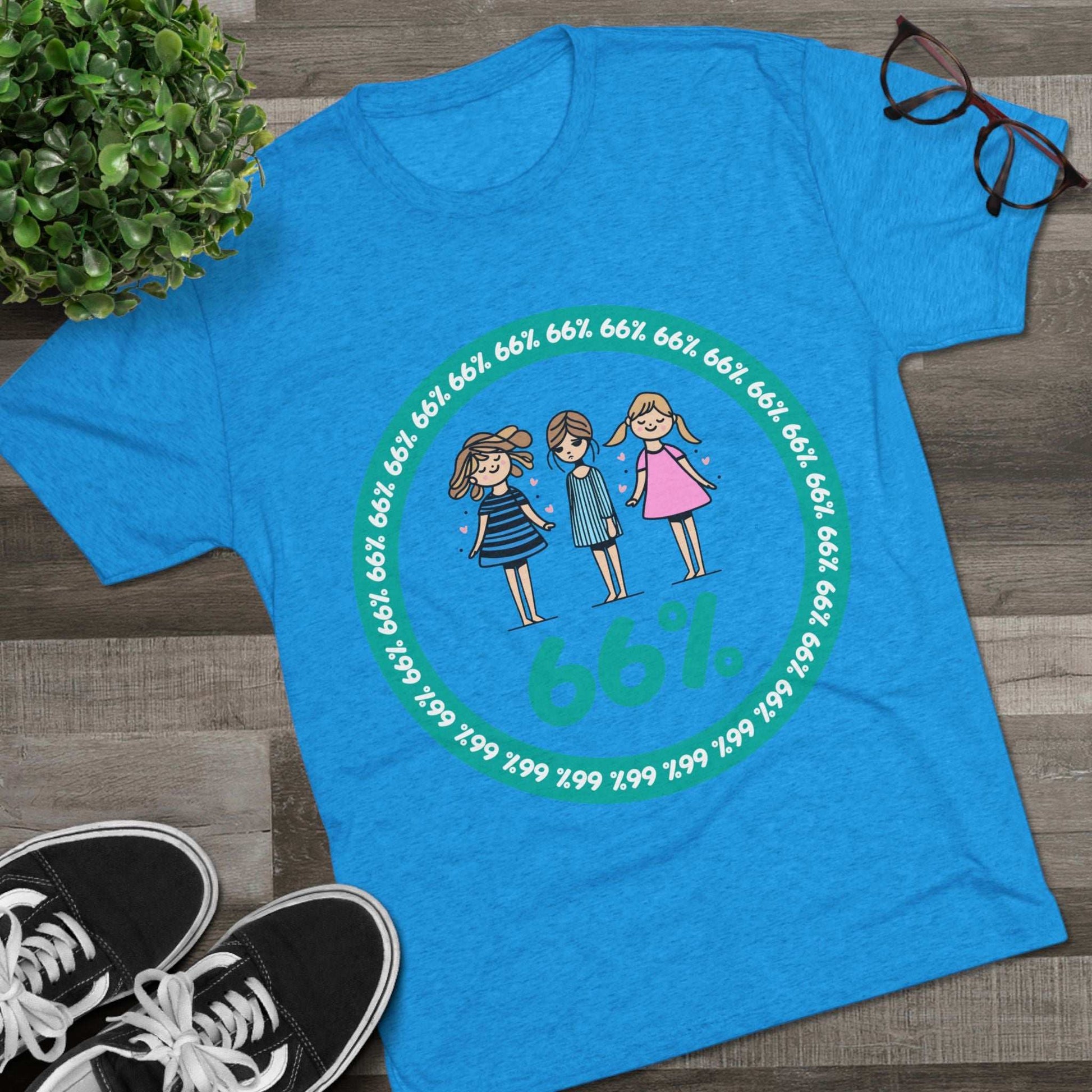 Flat-lay of tri-blend tee with three cartoon girls inside a teal 66% circle and repeating 66% border