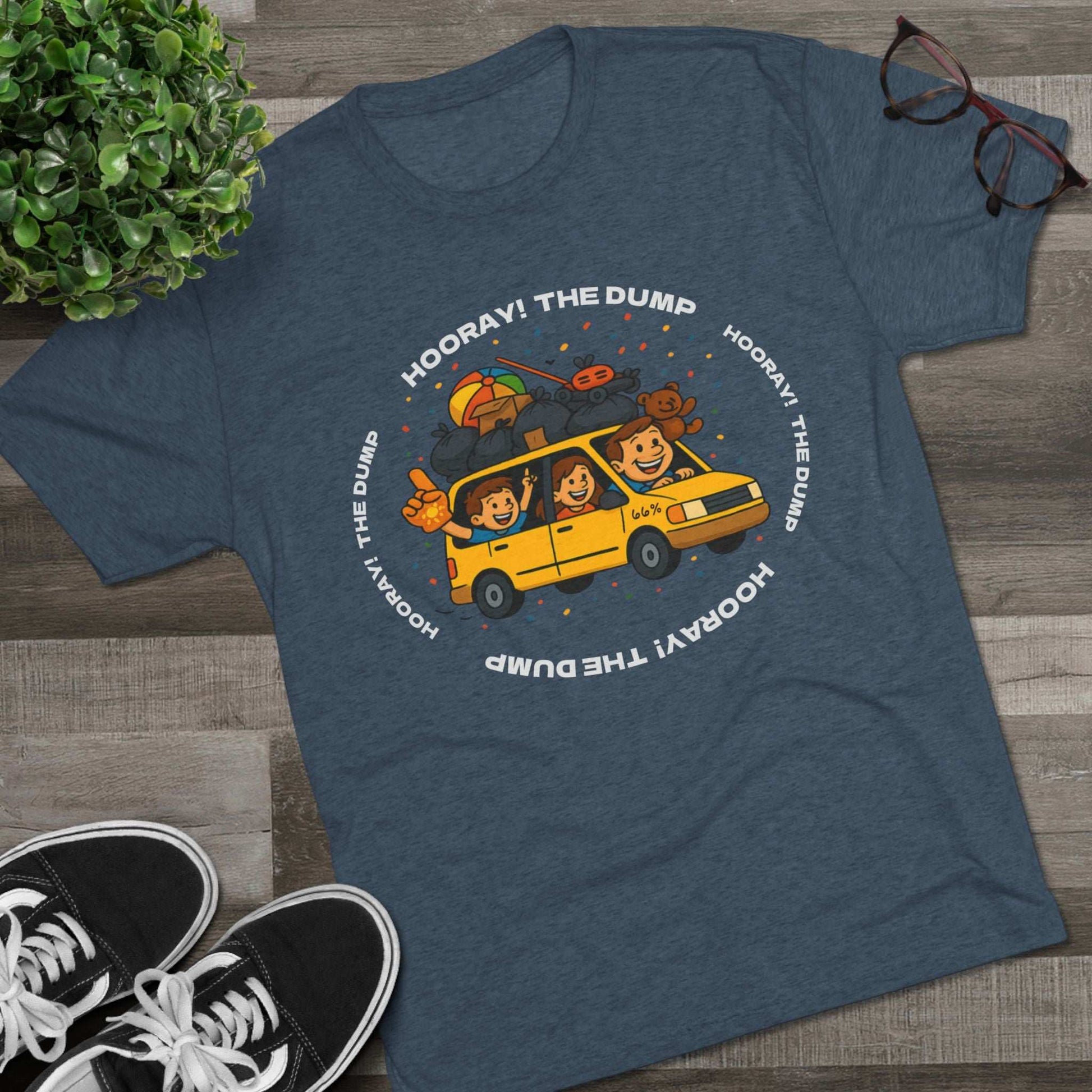 Cartoon yellow “66%” minivan T-shirt design with roof piled high in trash bags, lawnmower and beach ball, plus a dad driving and two excited kids waving with confetti.