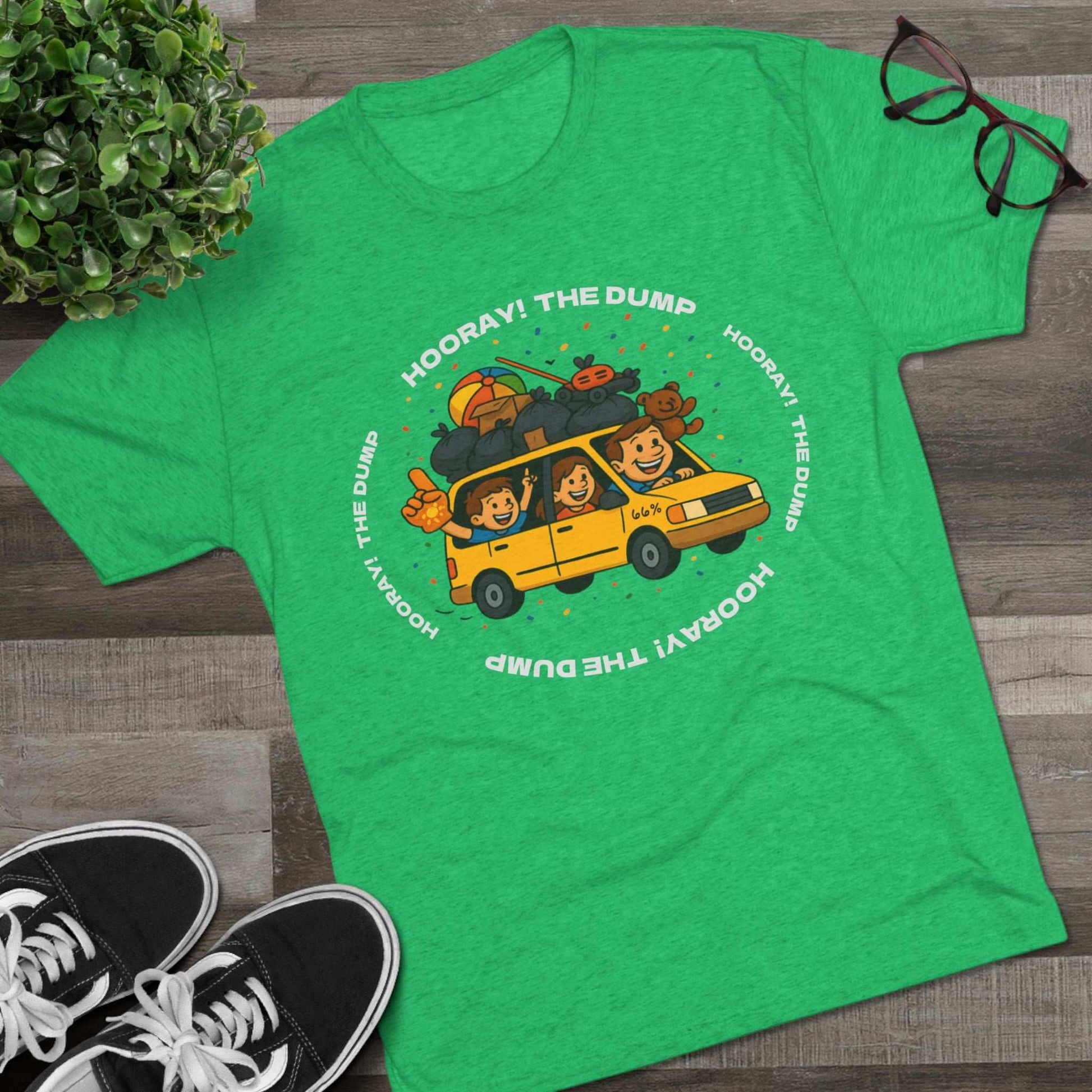 Cartoon yellow “66%” minivan T-shirt design with roof piled high in trash bags, lawnmower and beach ball, plus a dad driving and two excited kids waving with confetti.