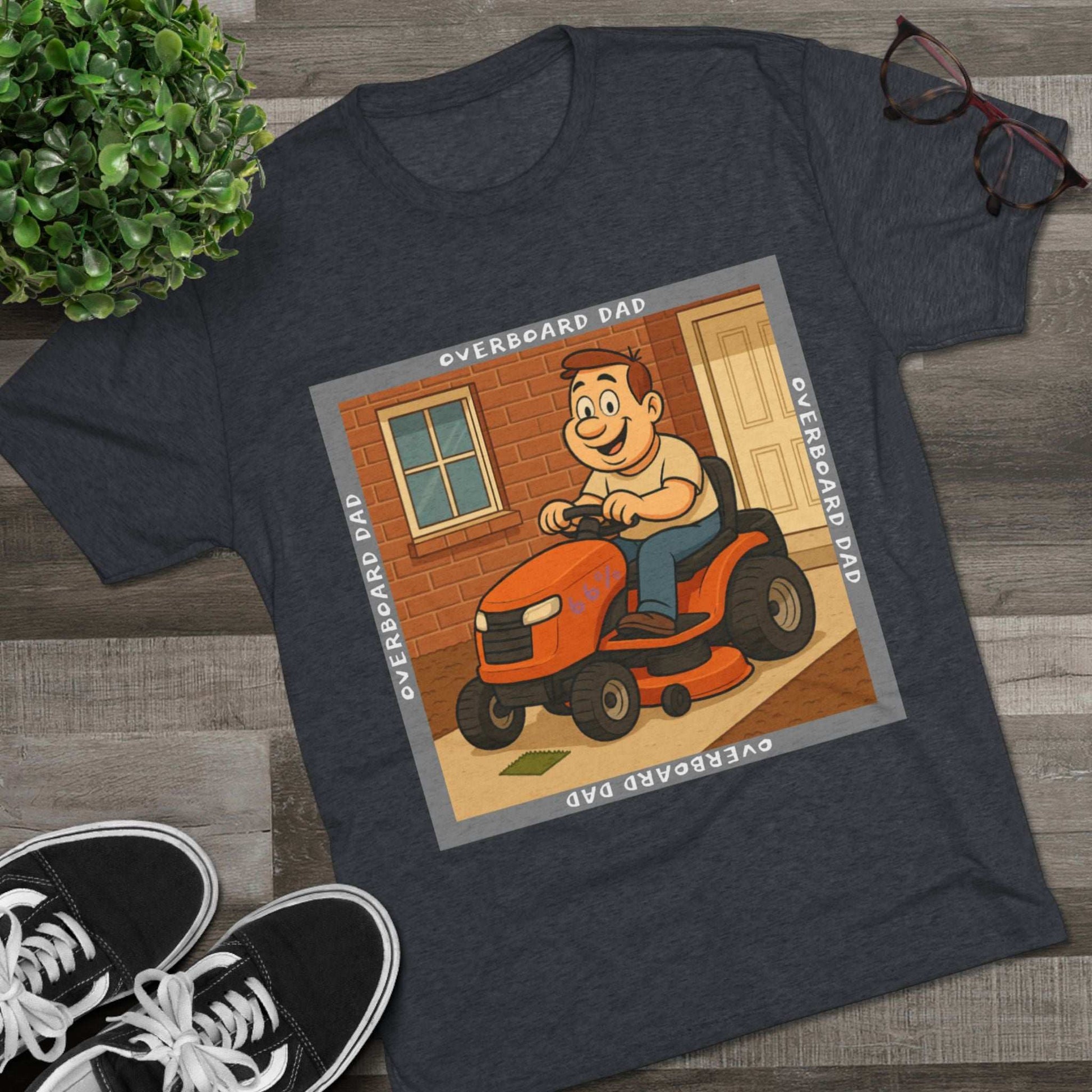 Overboard Dad Mower 66% Tri-Blend Tee — graphic tee, flat-lay with cartoon dad on ride-on mower, gray ‘OVERBOARD DAD’ square border, 66% decal, casual vintage style.
