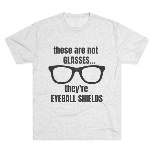 Light heather tri-blend tee flat-laid, printed with black glasses graphic and text ‘these are not GLASSES... they’re EYEBALL SHIELDS.