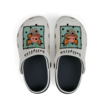 White slip-on clogs decorated with colorful Jibbitz: each shoe has a teal square graphic showing a cute jellyfish with butterfly wings and scattered gold dot accents, plus ‘Bellyfish’ branding on the straps