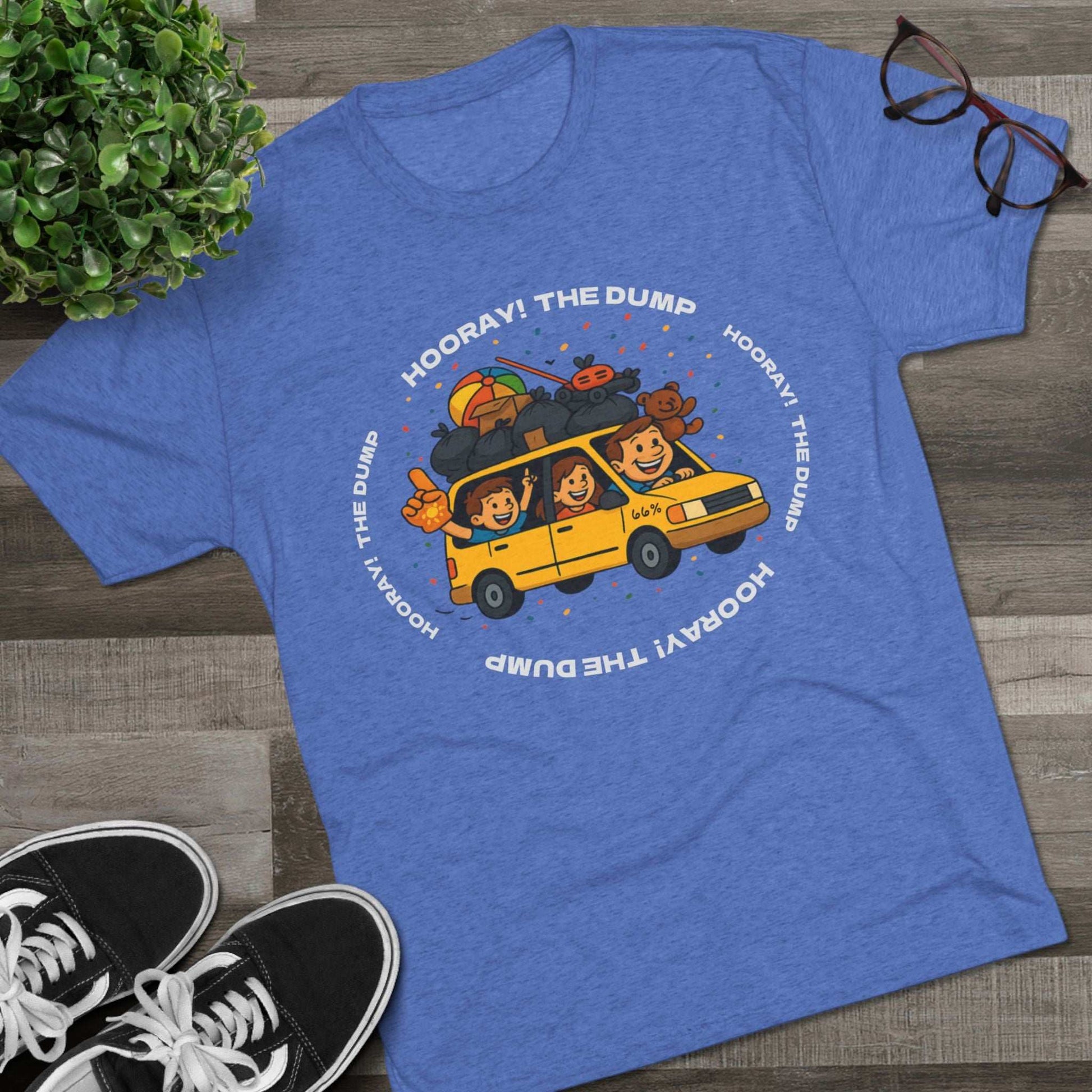 Cartoon yellow “66%” minivan T-shirt design with roof piled high in trash bags, lawnmower and beach ball, plus a dad driving and two excited kids waving with confetti.