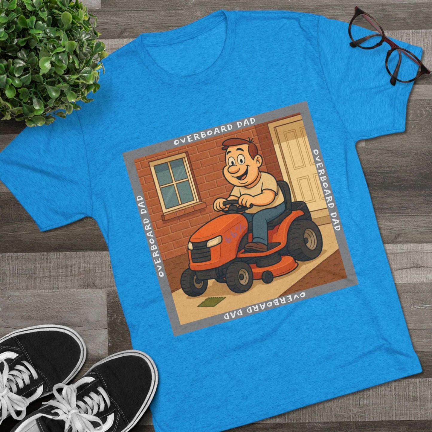 Overboard Dad Mower 66% Tri-Blend Tee — graphic tee, flat-lay with cartoon dad on ride-on mower, gray ‘OVERBOARD DAD’ square border, 66% decal, casual vintage style.