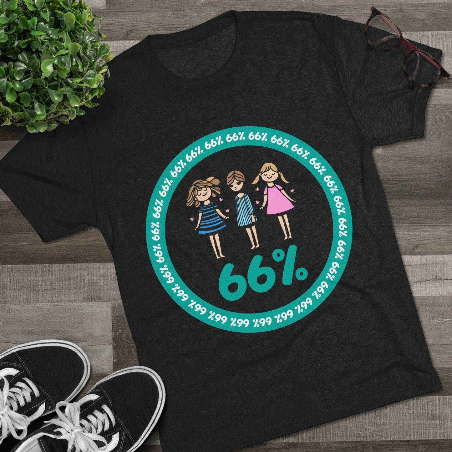 Flat-lay of tri-blend tee with three cartoon girls inside a teal 66% circle and repeating 66% border