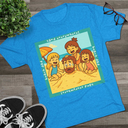 “Beach Dad Buried 66% Tri-Blend Tee — graphic tee flat-lay, cartoon dad sand-buried under umbrella, three kids playing, teal ‘sand everywhere!’ square border, ‘beach dad’ text, unisex casual style.