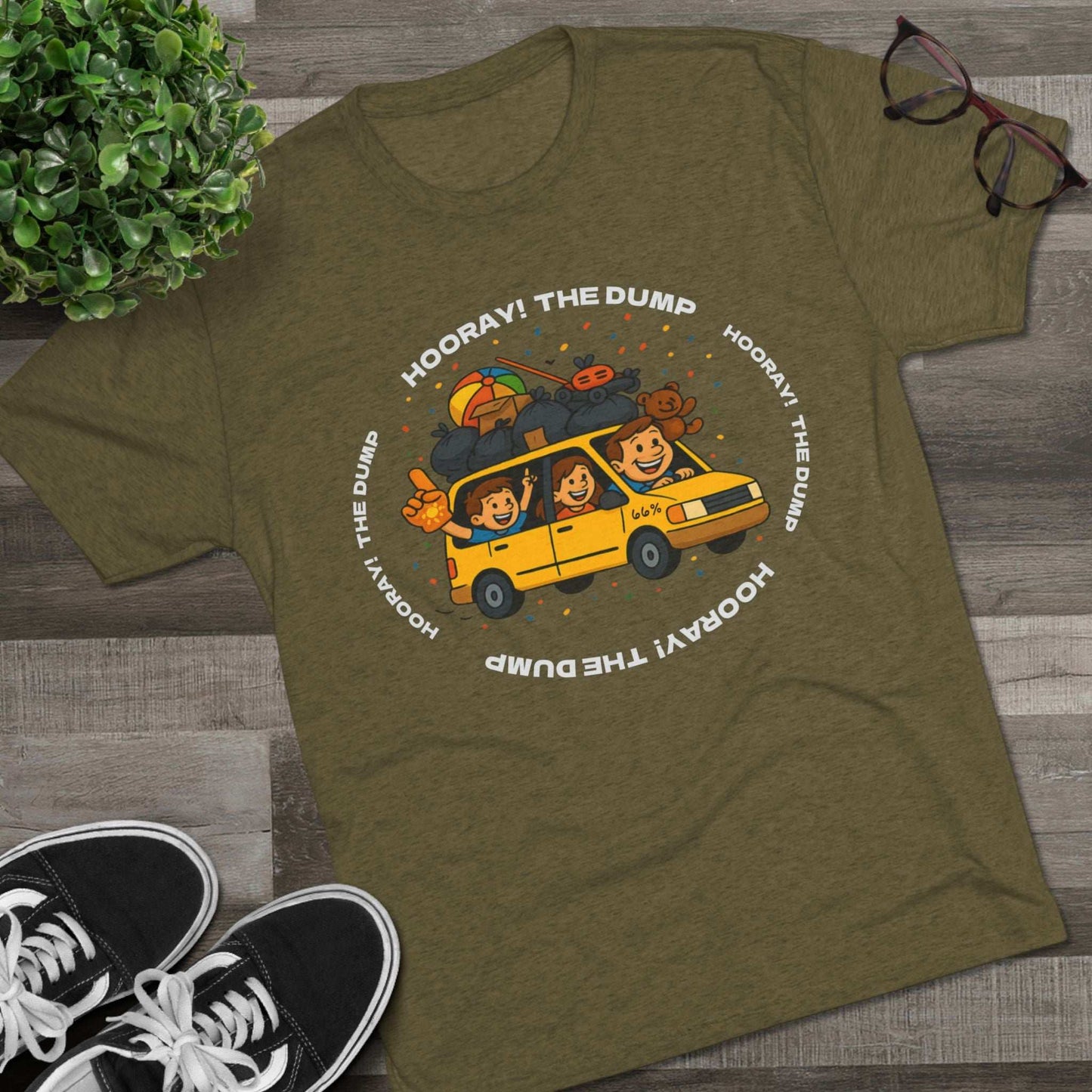 Cartoon yellow “66%” minivan T-shirt design with roof piled high in trash bags, lawnmower and beach ball, plus a dad driving and two excited kids waving with confetti.