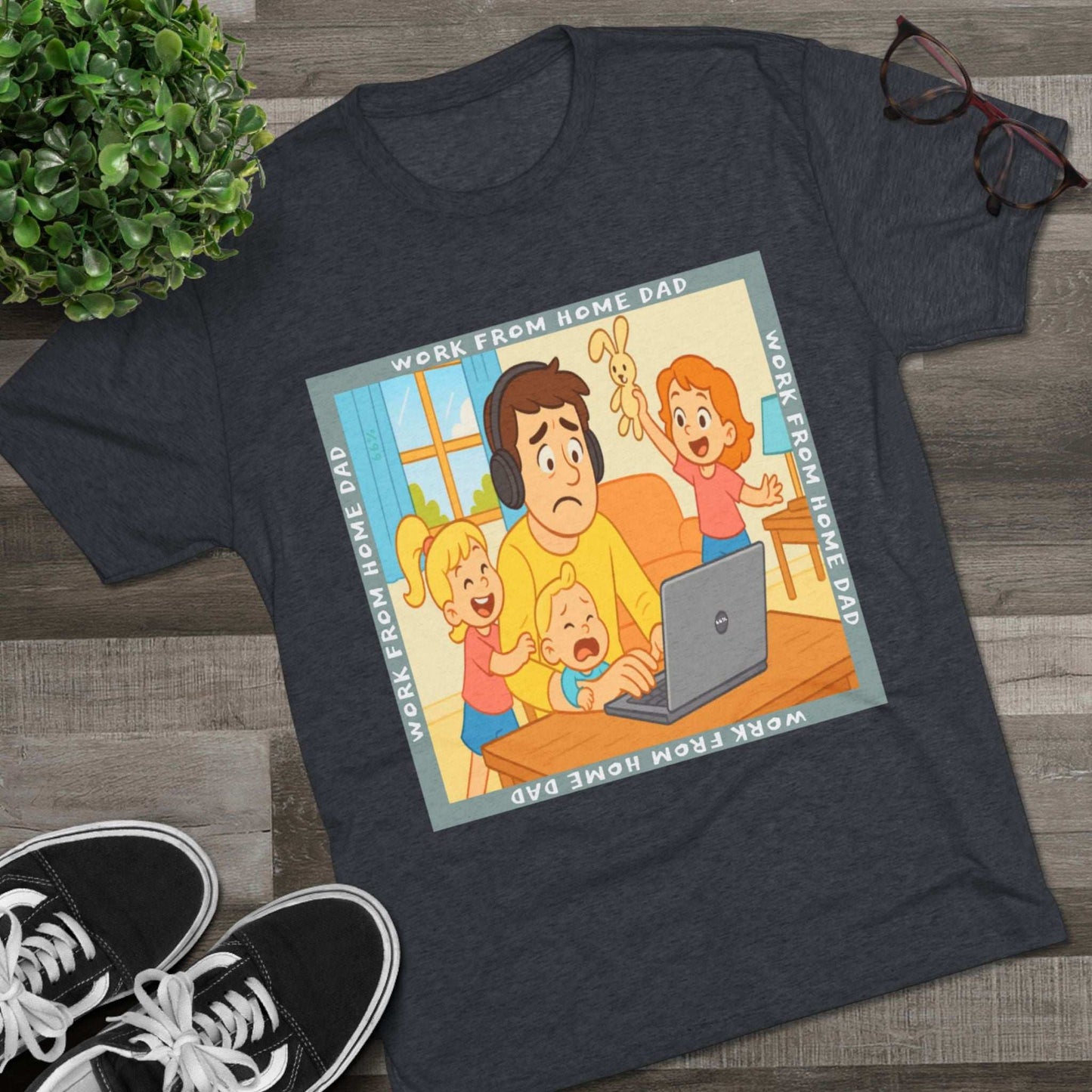 Work From Home Dad 66% Tri-Blend Tee — graphic tee flat-lay, cartoon dad with headphones typing on 66% laptop, three kids demanding attention, green WORK FROM HOME DAD square border, casual unisex style.