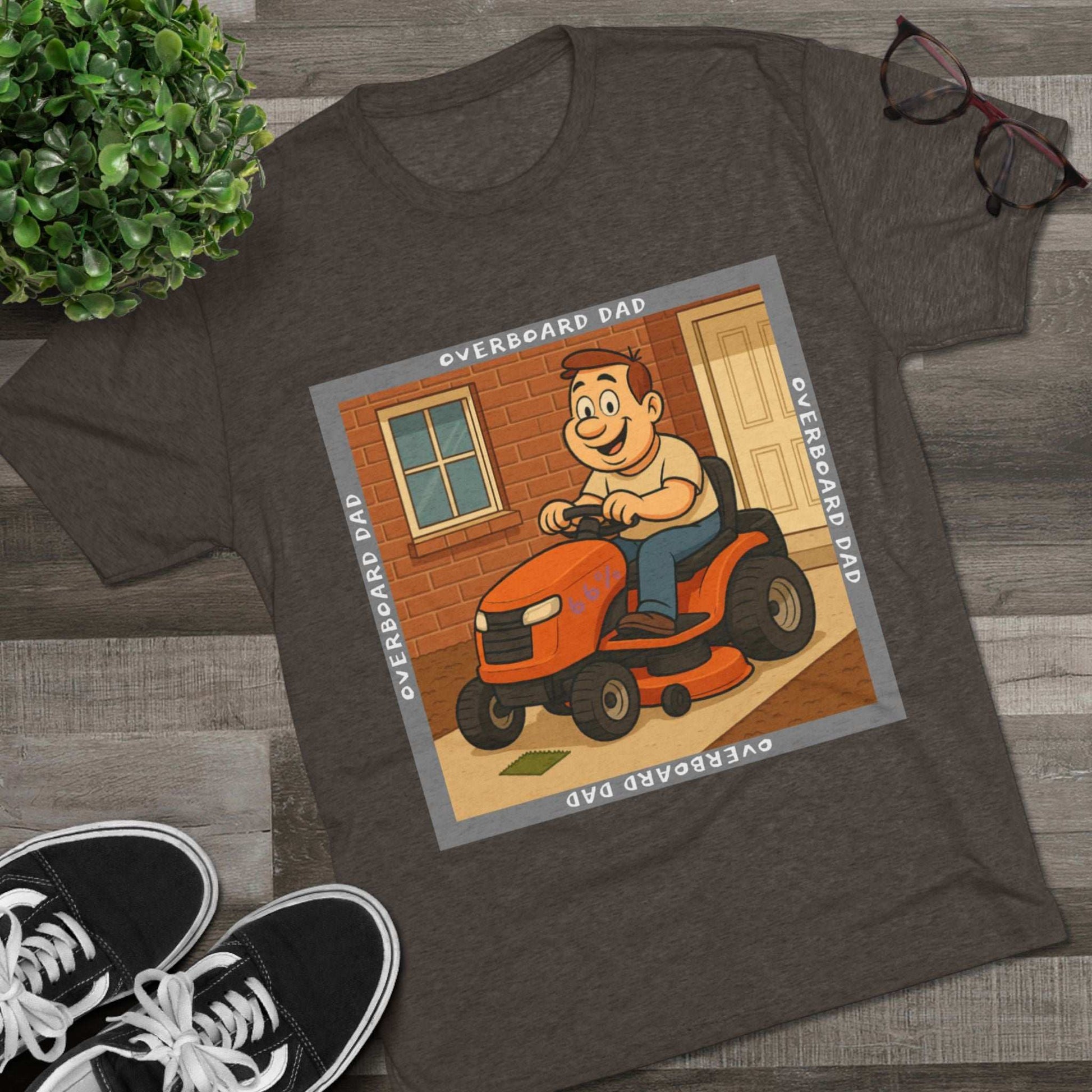 Overboard Dad Mower 66% Tri-Blend Tee — graphic tee, flat-lay with cartoon dad on ride-on mower, gray ‘OVERBOARD DAD’ square border, 66% decal, casual vintage style.