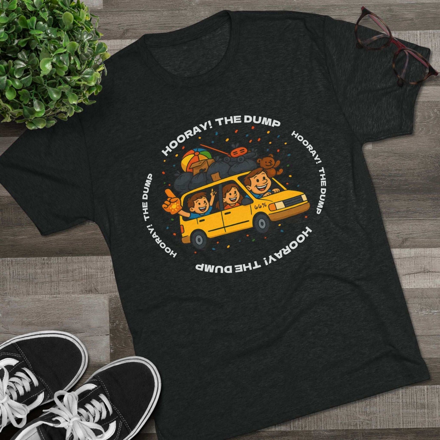 Cartoon yellow “66%” minivan T-shirt design with roof piled high in trash bags, lawnmower and beach ball, plus a dad driving and two excited kids waving with confetti.