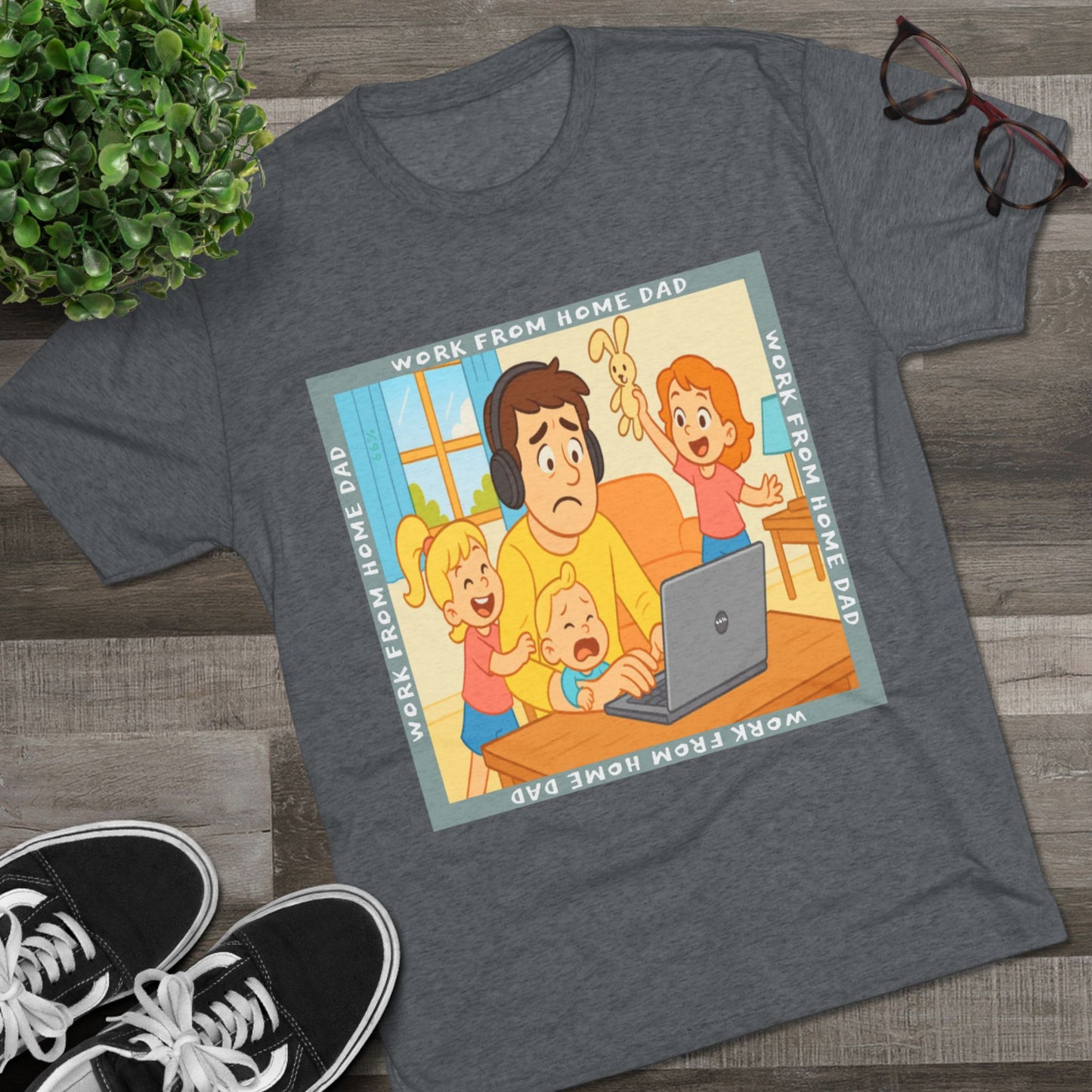 Work From Home Dad 66% Tri-Blend Tee — graphic tee flat-lay, cartoon dad with headphones typing on 66% laptop, three kids demanding attention, green WORK FROM HOME DAD square border, casual unisex style.