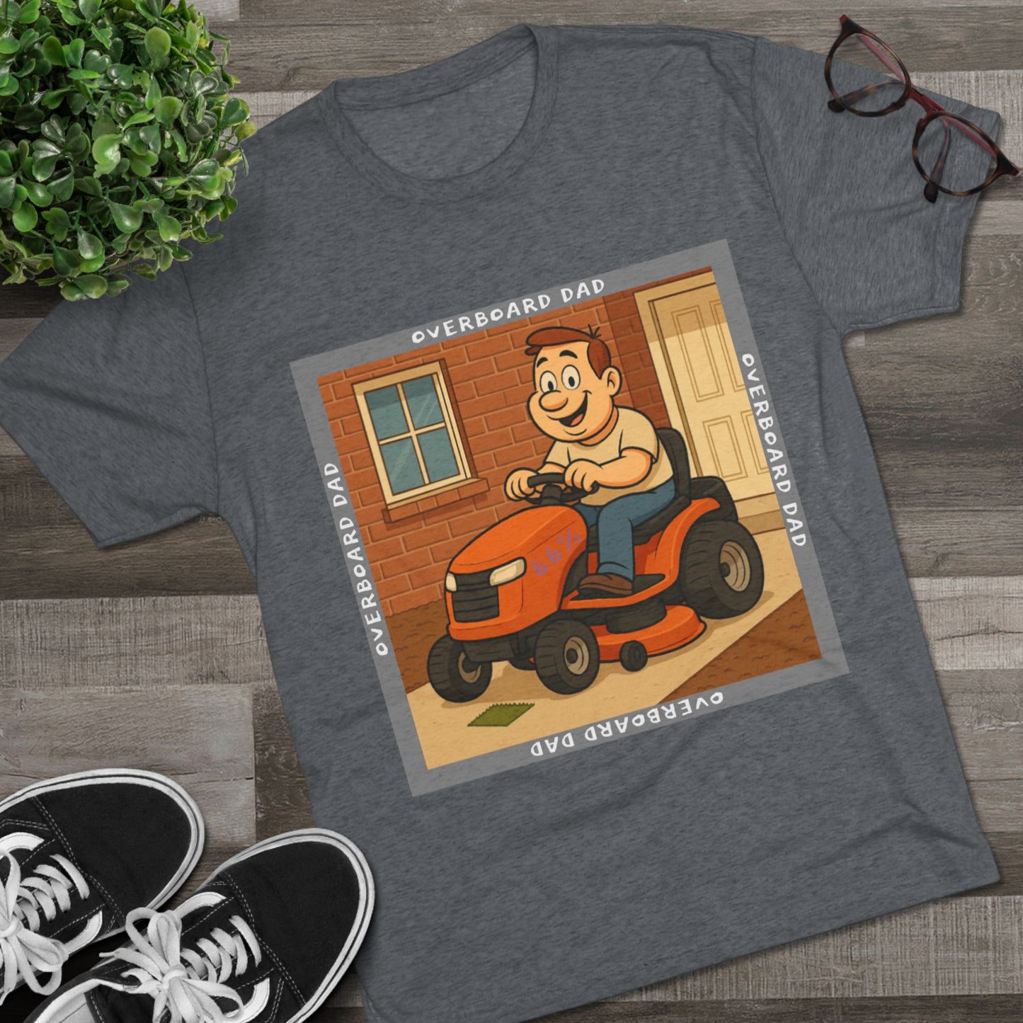 Overboard Dad Mower 66% Tri-Blend Tee — graphic tee, flat-lay with cartoon dad on ride-on mower, gray ‘OVERBOARD DAD’ square border, 66% decal, casual vintage style.