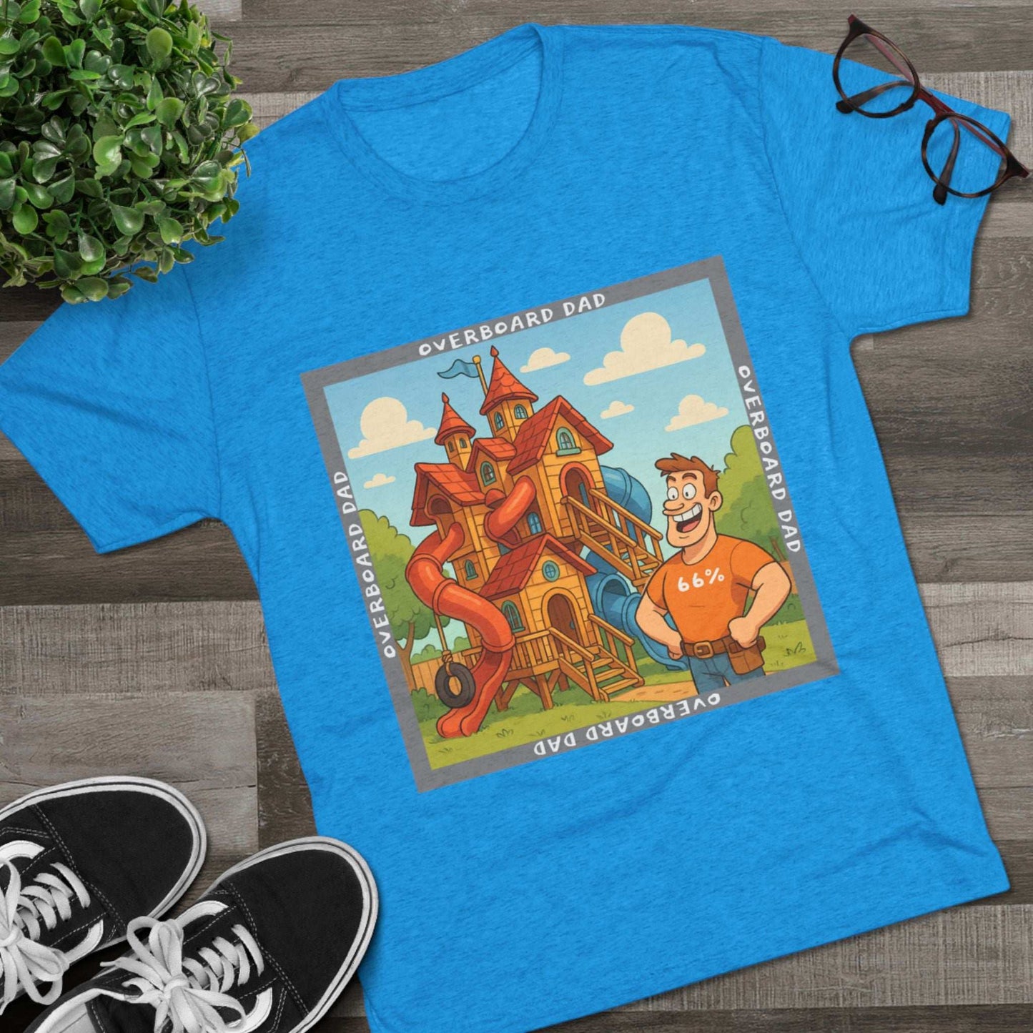 Funny cartoon dad standing proudly beside an enormous playhouse castle with slides, “Overboard Dad 66%” design on bright blue tri-blend t-shirt
