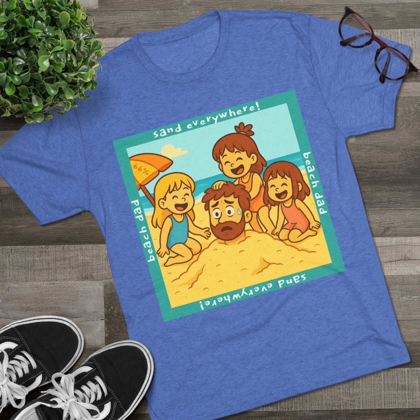 “Beach Dad Buried 66% Tri-Blend Tee — graphic tee flat-lay, cartoon dad sand-buried under umbrella, three kids playing, teal ‘sand everywhere!’ square border, ‘beach dad’ text, unisex casual style.