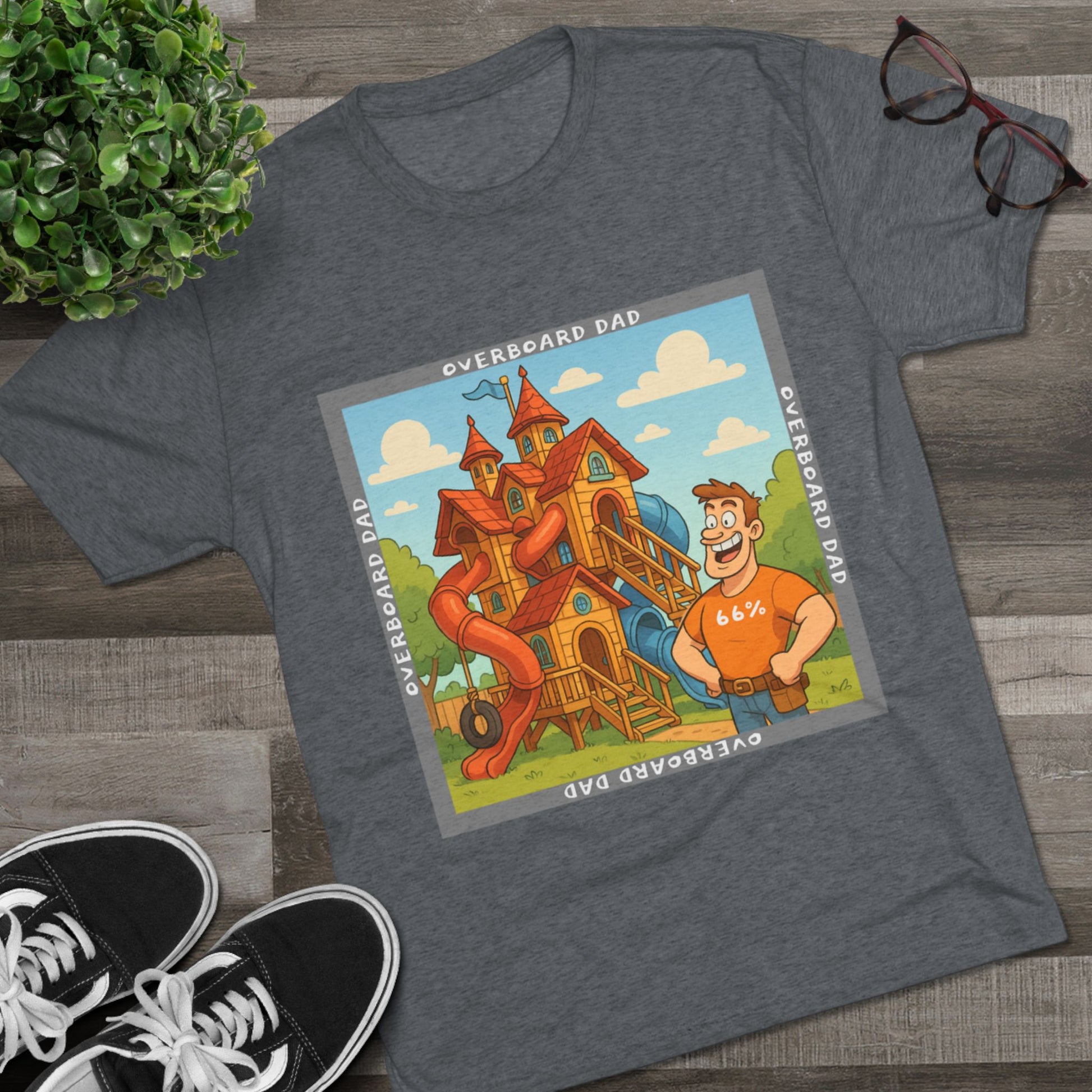 Funny cartoon dad standing proudly beside an enormous playhouse castle with slides, “Overboard Dad 66%” design on bright blue tri-blend t-shirt